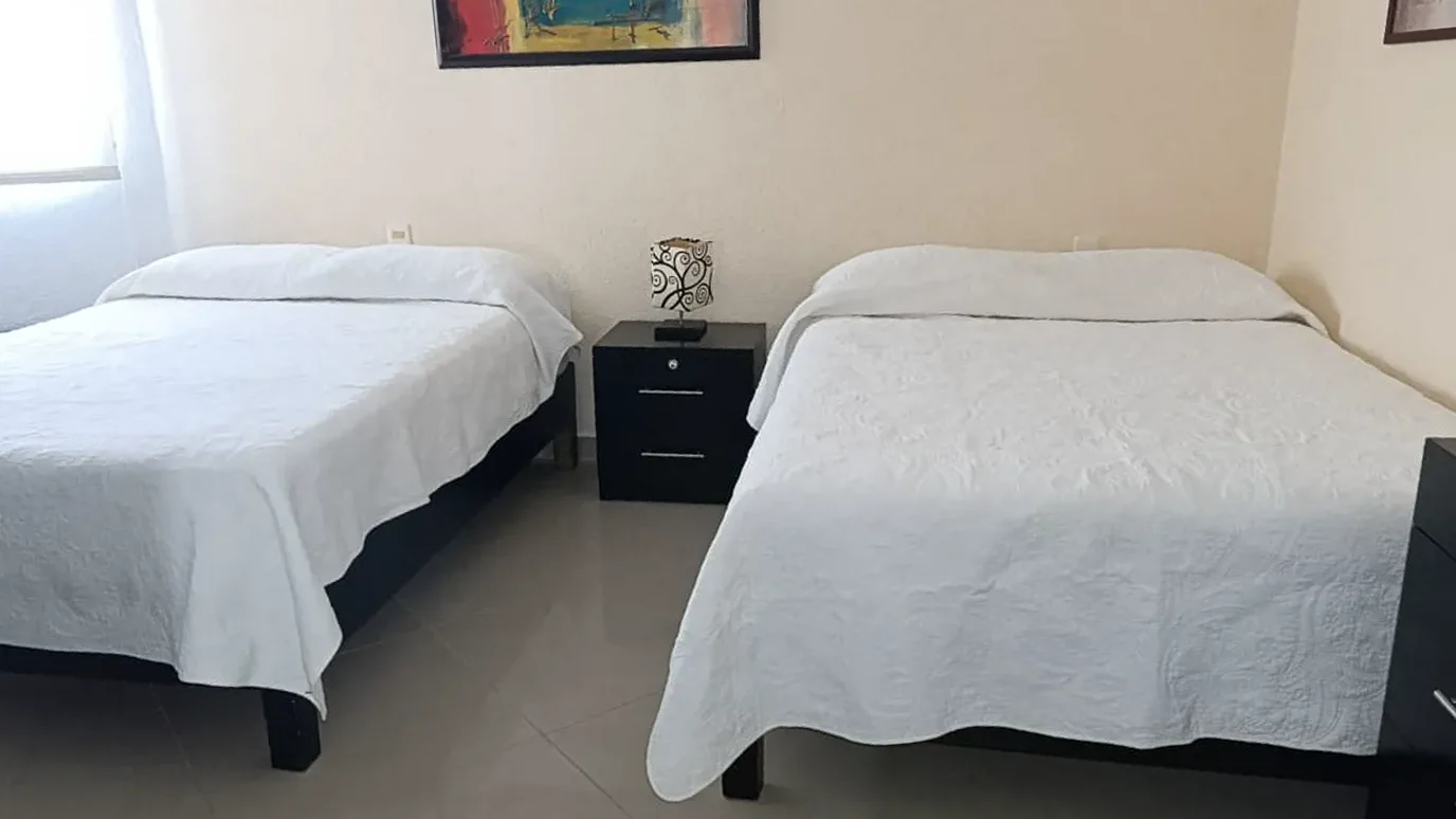 Recámara principal con dos camas matrimoniales